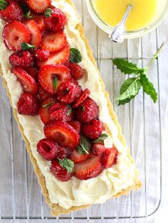 a pastry with strawberries and mint on top next to a glass of orange juice