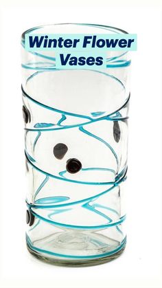 a glass vase with some black and white balls in it's bottom, which is labeled winter flower vases