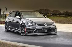 the volkswagen golf gtr is parked in front of a parking lot