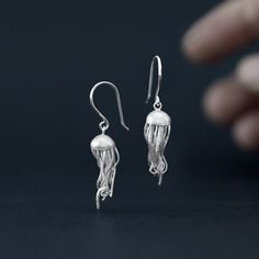 Get caught up in the tentacles of our little jellyfish.  Earrings made in sterling silver with a matte, sandblasted finish.  This design of dangling earrings has a total length of 4 centimeters and the diameter of the jellyfish head is 0.8 millimeters.  Don't hesitate and show off these fantastic jellyfish in your daily life. Our designs have handmade finishes, so measurements may vary slightly. Jellyfish Jewelry, Jellyfish Earrings, Marine Animals, Dangling Earrings, Earrings Sterling Silver, Jellyfish, Sterling Earrings, Sterling Ring, Daily Life