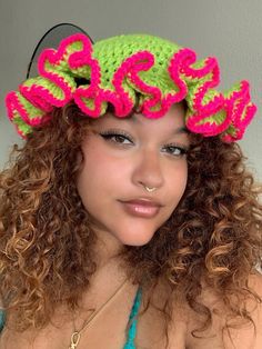 a woman with curly hair wearing a crochet hat