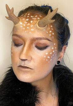 a woman with deer antlers on her head and white dots all over her face