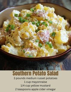 a bowl filled with potato salad on top of a wooden table