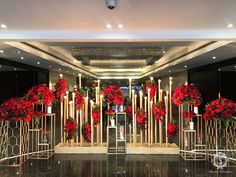 the entrance to a hotel decorated with red flowers and candles for holiday celebrations or special occasions