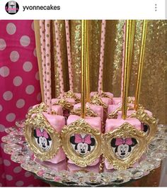 there is a cake decorated with pink and gold minnie mouses on it's stand