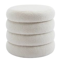 four white round cushions stacked on top of each other in front of a white background