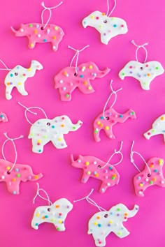 some pink and white elephant ornaments on a pink background