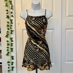 a mannequin is standing in front of a door wearing a black and gold dress