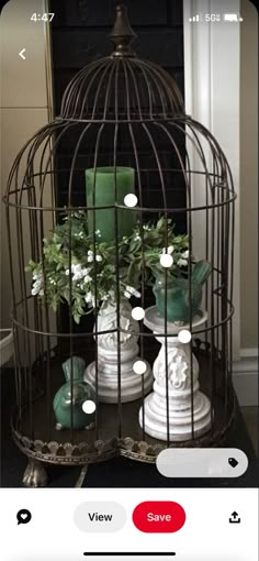 a birdcage with candles and flowers in it