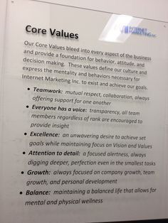 a sign that is on the wall in front of a building with information about core values