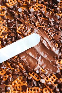 a knife sitting on top of chocolate covered pretzels