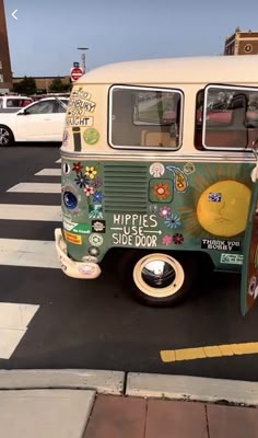 an old vw bus is parked on the side of the road with stickers all over it