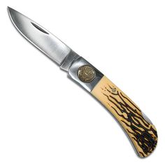 a knife that is sitting on top of a white surface with black and brown designs