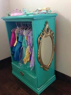 a blue cabinet with mirrors and clothes hanging on it