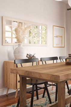 a dining room table with chairs and a vase