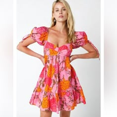 Slip Into The Jessie Pink Floral Babydoll Mini Dress For A Delightful Brunch With Friends! This Dress Features A Charming Blend Of Pink, Yellow, And Orange In Its Floral Design, Crafted From Woven Fabric For A Light And Airy Feel. Its Sweetheart Neckline And Empire Waist Bodice Are Complemented By Puffy Short Sleeves, Complete With Ties And Elasticized Shoulders For A Snug Fit. The Babydoll Style Cascades Into A Playful Mini Skirt, Finished With A Ruffle Hem For A Touch Of Whimsy. Fully Lined Fo Pink Puff Sleeve Floral Dress For Summer, Casual Pink Floral Dress With Puff Sleeves, Pink Flowy Cotton Mini Dress, Flowy Pink Cotton Mini Dress, Pink Bohemian Puff Sleeve Dresses, Beach Cotton Dress With Puff Sleeves, Cotton Puff Sleeve Beach Dress, Cotton Puff Sleeve Dress For Beach, Pink Puff Sleeve Mini Dress For Beach