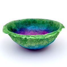 a green and blue bowl sitting on top of a white table