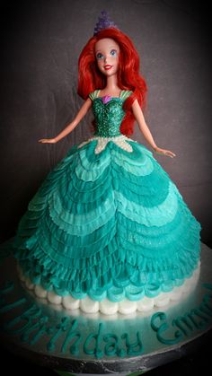 there is a birthday cake with a doll on it that has been made to look like princess ariel from the little mermaid