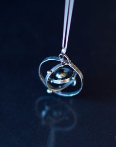 This kinetic solar system is hand made in sterling silver  Spinning Solar System… Astronomy Necklace, Solar System Necklace, Outer Planets, Wire Jewelry Patterns, Space Jewelry, Space Planets, Heart Pendant Gold, Solar System, Modern Jewelry