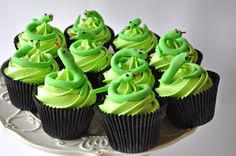 cupcakes with green frosting are on a white plate and decorated with icing