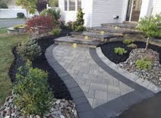 an outdoor patio with steps leading up to the front door and landscaping area in the foreground