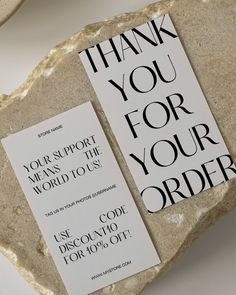 two thank you for your order cards sitting on top of a rock