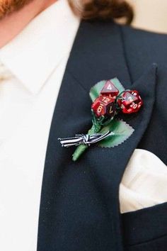 a man wearing a suit and tie with dice boutonnieres on his lapel