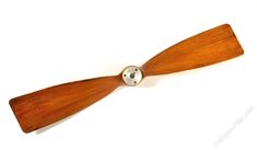 a wooden propeller on a white surface with a metal ball in the center and two blades attached to it