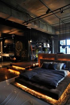 a large bed sitting in the middle of a bedroom next to a table with candles on it