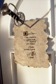 an old piece of paper hanging on a door with a keychain attached to it