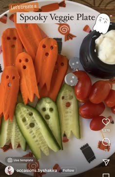 a plate with carrots, cucumbers and tomatoes on it