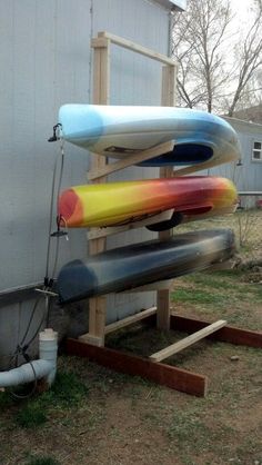 three surfboards are stacked on top of each other in front of a building with a water hose attached to it