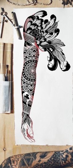 a drawing of a woman's body with tattoos on her arm and leg, next to some paintbrushes