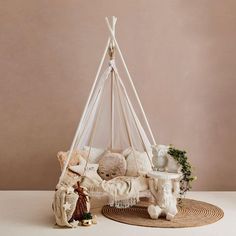 a teddy bear sitting in a teepee next to other stuffed animals and decorations on a rug