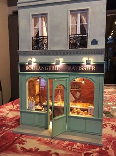 a doll house is set up to look like a pastry shop with its doors open