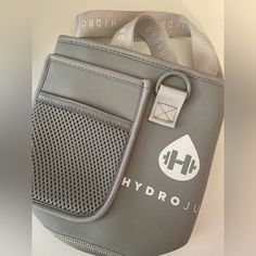 a gray and white bag with the word hydro on it's side, hanging from a hook