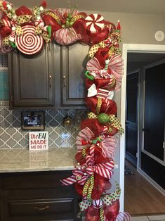 a kitchen decorated for christmas with candy and lollipops on the front door