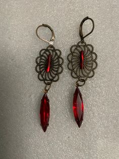 These earrings are in the style of Art Nouveau.  The earrings are handmade and comprised of brass filigree stampings, red navette crystals and red crystal bugle beads.  The earrings have a drop length of 2.75 inches, including the lever back closure.  If you prefer wires to lever backs just let me know. These are lightweight earrings. Red Dangle Filigree Jewelry, Red Filigree Dangle Jewelry, Ornate Red Dangle Earrings, Ornate Red Filigree Earrings, Ornate Red Earrings For Party, Vintage Red Dangle Chandelier Earrings, Red Vintage Dangle Chandelier Earrings, Red Filigree Dangle Earrings, Red Vintage Chandelier Dangle Earrings