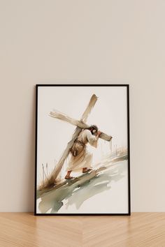 a painting of jesus carrying the cross on a wooden table next to a white wall