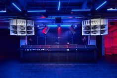 an empty stage set up for a concert with red and blue lights in the background