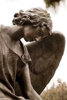 a statue of an angel holding his head