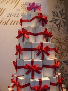 a christmas tree made out of white boxes with red bows