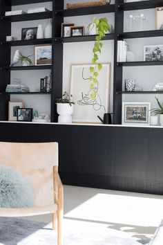 a living room filled with lots of furniture and shelves full of pictures on the wall