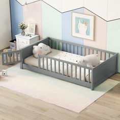 a baby's room with pastel walls and wooden flooring, including a grey crib