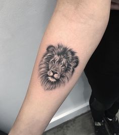 a black and white lion tattoo on the arm