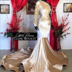 a mannequin is dressed in a gold and white gown with long sleeves on it