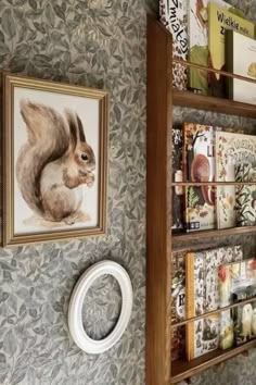 a book shelf filled with lots of books next to a wall mounted squirrel on it