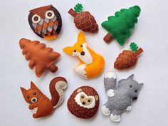 several felt animals and trees on a white surface