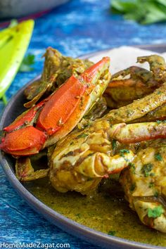 cooked crab legs with lemon and parsley sauce on a blue tablecloth, ready to be eaten