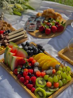 there are many different fruits on the trays that is ready to be served at this party